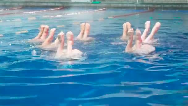 花样游泳。在冬天, 细长的腿女孩运动员在开放的游泳池里伸出水面。年轻女孩在游泳池里学习游泳。年轻女孩接受训练, 在游泳池里进行竞技游泳 — 图库视频影像