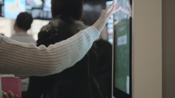 Girl välja mat via självbetjänings maskin på snabbmat restaurang. Personer som använder Self-Service touch Terminal gör ett köp av mat — Stockvideo