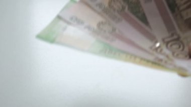 İnsan eli ile a yelpaze-in para. Para masanın üzerine koyarak. Para saymak için. Eller Lirası üstünde beyaz bir tablo yeniden sayılması. İnsanlar el Rus ruble banknotlar küçük bir beyaz 100 ve 200 ortaya konuyor