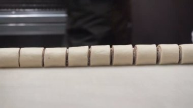 Olay: aşçı tepsi pişirme bir metal bir tarçın rulo için fırın tepsisi hazırlar. Tarçın rulo imalatı. İştah açıcı tarçınlı çörek yapışkan buns. Ekmek yapım ürünleri.