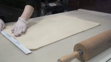 Olay: Cook hamur şekillendirme bir cetvel ile hamur levha hizalar. Tarçın rulo imalatı. Pastane. İştah açıcı tarçınlı çörek yapışkan buns 