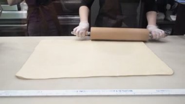 Olay: Cook hamur şekillendirme bir oklava ile hamur levha hizalar. Tarçın rulo imalatı. Pastane. İştah açıcı tarçınlı çörek yapışkan buns 