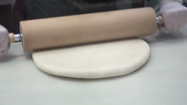 Scenen: Cook rullar degen med en brödkavel, forma degen. Produktion av kanelbullar. Bageriprodukter. Aptitretande kanelbullar kladdiga bullar — Stockvideo
