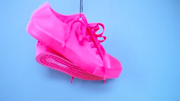 挂着明亮的彩色运动鞋。时尚女时尚教练。时尚的希普斯特普利莫斯特明亮的粉红色蓝色运动鞋。最小的流行艺术概念。迷幻的平淡无奇。艺术设计背景 — 图库视频影像
