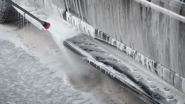 Zpomalené Video mytí proces na samoobslužných služeb Car Wash Proud vody se vysoký tlak smýt špínu z auta. Boční pohled. Pěnový čisticí prostředek kanalizace z povrchu — Stock video