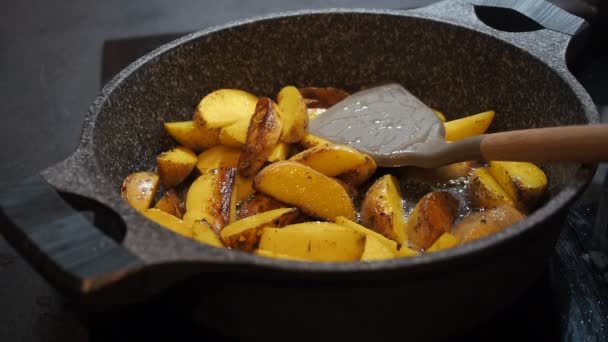 Fond de cuisine maison. Nourriture grasse. Pommes de terre non pelées jaunes rustiques appétissantes cuites à l'huile d'olive frites dans une poêle en temps réel fermer. Préparation frites maison, frites maison, frites américaines, frites — Video