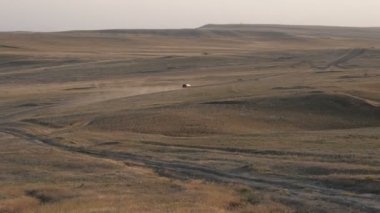 SUV çöl tozu yolu. Bir SUV bir kir yol sürmek, bir çöl manzara ortasında toz bir sütun yükseltmek. Düz görüntüleri