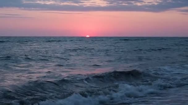 Όμορφο κόκκινο ηλιοβασίλεμα στην παραλία καταπληκτικά χρώματα φως ακτίνα λάμπει μέσα από το συννεφάκι Θαλασσοτοπίου στο ροζ ηλιοβασίλεμα θάλασσα κύματα ήλιος έχει μισό πάει στο νερό 30fps — Αρχείο Βίντεο