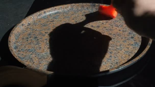 Der Prozess des Kochens hausgemachter Pfannkuchen. die Köchin weidet die heiße Pfanne gießt Pfannkuchenteig mit Schöpfkelle. Kochen eines frischen Frühstücks an einem sonnigen Morgen. Fettiges Essen. appetitliche Pfannkuchen backen in einer Pfanne — Stockvideo