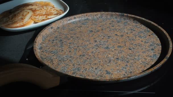 Процесс приготовления самодельных блинчиков. Повар выливает блинное тесто на горячую сковороду с ковшами. Готовить свежий завтрак в солнечное утро. Жирная еда. Аппетитные блины, выпекаемые в сковороде — стоковое видео