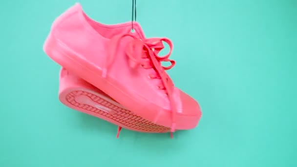 Κρέμονται φωτεινά χρωματιστά αθλητικά παπούτσια. Μόδα Γυναικεία μοντέρνα εκπαιδευτές. Κομψό ροζ τιρκουάζ χρώμα αθλητικά παπούτσια. Ελάχιστη ποπ τέχνη. Το ψυχεδελικό διαμέρισμα. Φόντο σχεδίασης τέχνης — Αρχείο Βίντεο