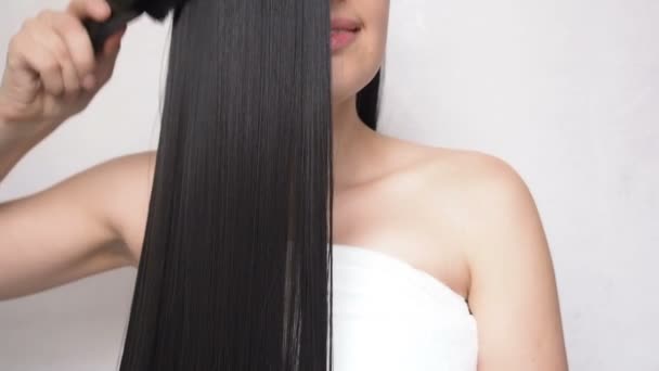 Junges Mädchen kämmt lange glatte Haare nach dem Duschen — Stockvideo