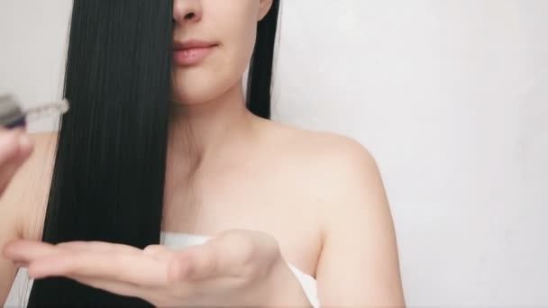 Junges Mädchen schmiert Haarpflegeöl. hübsche Dame kümmert sich um Haare — Stockvideo
