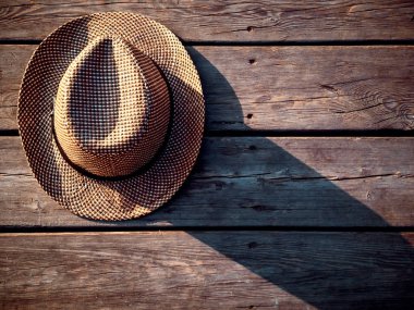 Ahşap arka plan üzerinde hasır şapka üst görünümü. Horisontal görüntü
