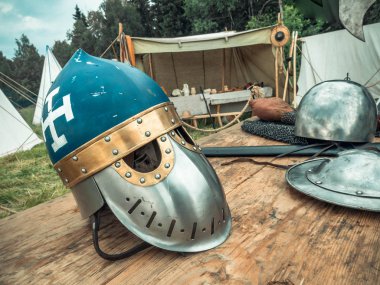 Ortaçağ sahnesi. Ortaçağ şövalye özellikleri kask, zincir posta, kalkan buckler, kılıç, halberd vardır. Ortaçağ yaşamının yeniden inşası
