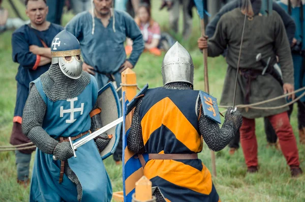 RITTER WEG, MOROZOVO, ABRIL 2017: Festival de la Edad Media Europea. Justas medievales en cascos y cota de malla batallan con espadas con escudos en sus manos — Foto de Stock