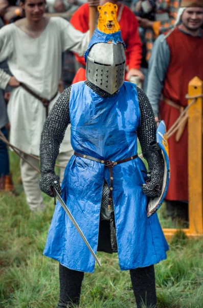 RITTER WEG, MOROZOVO, ABRIL 2017: Festival de la Edad Media Europea. Retrato de caballero medieval en casco y cota de malla batalla sobre espadas con escudo en la mano . — Foto de Stock
