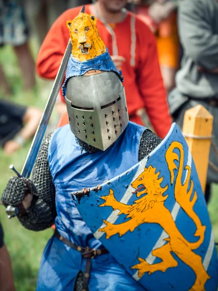 RITTER WEG, MOROZOVO, ABRIL 2017: Festival de la Edad Media Europea. Retrato de caballero medieval en casco y cota de malla batalla sobre espadas con escudo en la mano . —  Fotos de Stock