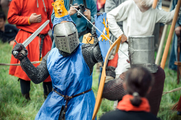 RITTER WEG, MOROZOVO, APRIL 2017: Festival of the European Middle Ages. Medieval joust knights in helmets and chain mail battle on swords with shields in their hands