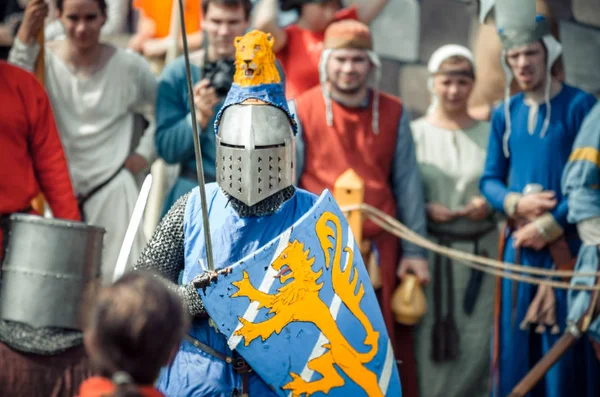 RITTER WEG, MOROZOVO, ABRIL 2017: Festival de la Edad Media Europea. Retrato de caballero medieval en casco y cota de malla batalla sobre espadas con escudo en la mano . —  Fotos de Stock