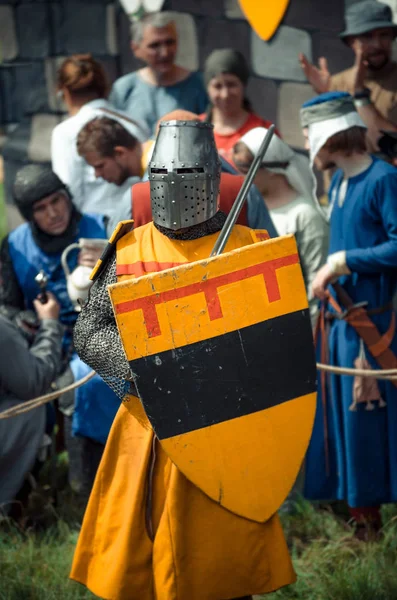 RITTER WEG, MOROZOVO, ABRIL 2017: Festival de la Edad Media Europea. Retrato de caballero medieval en casco y cota de malla batalla sobre espadas con escudo en la mano . —  Fotos de Stock