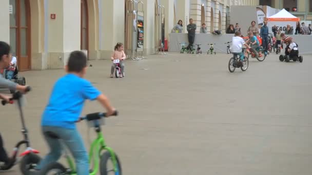Москва, Россия - 12 апреля 2019 года: Дети ездят на велосипедах, скутерах и легковых автомобилях в зале интернированного центра - в помещении для картинга. Детская игровая площадка — стоковое видео