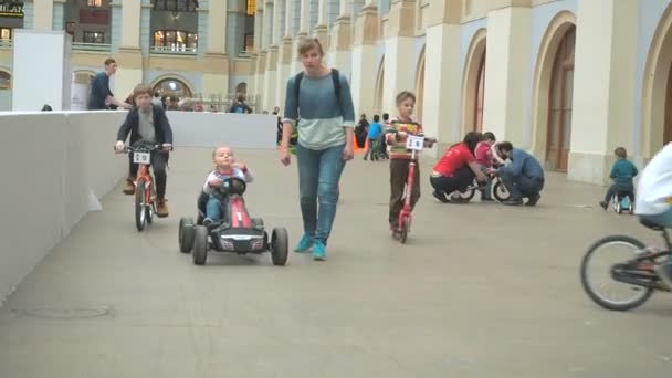 Moscú, Rusia - 12 de abril de 2019: Niños montando bicicletas, scooters y coches pequeños en la sala del centro de entretenimiento - Instalaciones de karting interior. Zona de juegos infantil — Vídeos de Stock
