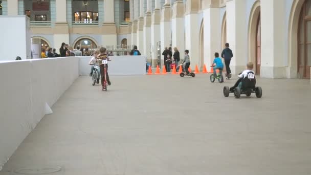 Moscú, Rusia - 12 de abril de 2019: Niños montando bicicletas, scooters y coches pequeños en la sala del centro de entretenimiento - Instalaciones de karting interior. Zona de juegos infantil — Vídeos de Stock