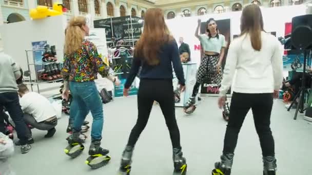 Moscow, Russia - April 12, 2019: Younh girl team in Kangaroo jumps anti gravity fitness boots doing endurance exercises at gym indoor. People are running on the spot in jumper boots. Female in — Stock Video