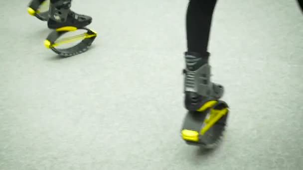 Moscou, Rússia - 12 de abril de 2019: Canguru pula menina botas anti gravidade fitness no ginásio indoor. Correndo no local em botas de jumper. Pernas femininas em leggings e em kangoo botas de salto com molas no — Vídeo de Stock