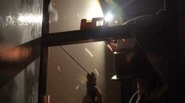 Kaynakçı işçi atlama kaynak gerçekleştirir. İşçi kaynakçı ark kaynağı süreci Metal yapılar gerçekleştirir. Kaynak Makinası kıvılcımlar uçuşuyordu. Kaynakçı Metal profilleri ikinci kat kapalı kaynak.