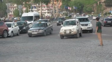 İnsanlar şehirdeki trafikten geçiyor.