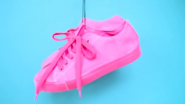 Opknoping Bright gekleurde Sneakers. Mode vrouw Trendy Trainers. Stijlvolle Hipster Plimsole helder roze blauw kleur Sneakers. Minimale popart Concept. Psychedelische plat lag. Art Design achtergrond — Stockvideo