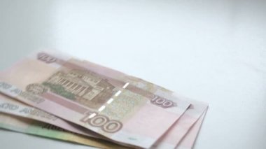 Para saymak için. Para beyaz bir masanın üzerine düşüyor. İnsanlar el hızlı Rus ruble banknotlar ücretleri 100 ve 200 atar ve beyaz bir arka plan üzerinde nominal 10 sikke
