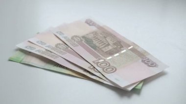 Para saymak için. Para beyaz bir masaya düşüyor. İnsanlar el Beyaz bir arka planda Rus ruble banknotlar ücretleri 200 ve 100 ve sikke nominal 10 atar