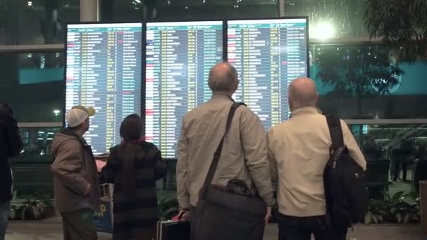 Ludzie czekają na wyjazd na lotnisku, deska odlotów, elektroniczny wyświetlacz rozkładu jazdy, statyczny. Elektroniczny wyświetlacz wyjazdów i przylotów na lotnisku Domodiedowo, Moskwa — Wideo stockowe