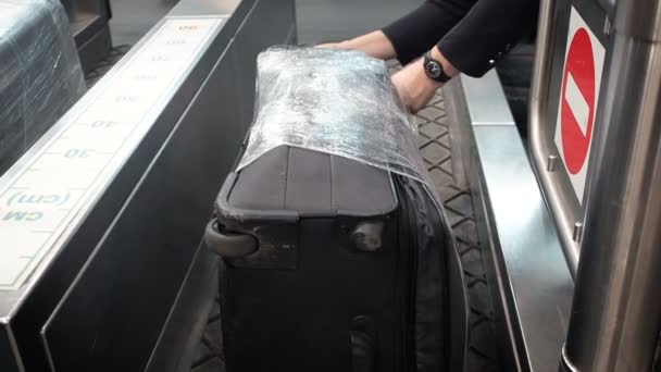 Vista da vicino di incollare sull'etichetta del bagaglio, attaccato alla valigia di plastica rossa in aeroporto. Il dipendente attacca un'etichetta bagaglio alla valigia del passeggero — Video Stock
