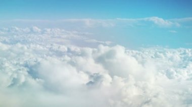 Hareket eden kar beyazı bulutları uçaktan görünüyor. Gökyüzü arka planı. Cennet. Bulutların arasında bir uçakta uçmak. Sakin arkaplan