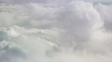 Hareket eden kar beyazı bulutları uçaktan görünüyor. Gökyüzü arka planı. Cennet. Bulutların arasında bir uçakta uçmak. Sakin arkaplan
