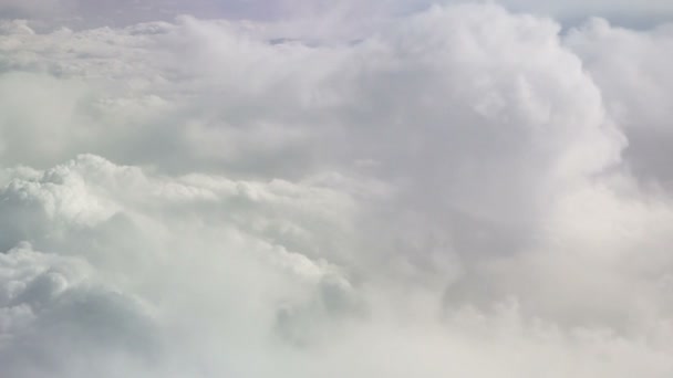 Vista desde el avión en movimiento nubes blancas como la nieve. Fondo del cielo. El Cielo. Volando en un avión entre las nubes. Fondo tranquilo. — Vídeos de Stock