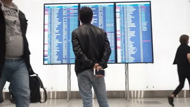 Moskva, Rusko – 6. května 2019: lidé čekají na odjezd na letišti, odletové desce, displej elektronického jízdního řádu na letišti, statický. Elektronické zobrazení odletů a příjezdů na letišti — Stock video