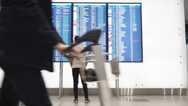 Москва, Россия - 6 мая 2019 года: Люди ждут вылета в аэропорту, вылета борта, аэропорта электронного расписания дисплея, статические. Электронное отображение отправлений и прибытий в аэропорт — стоковое видео