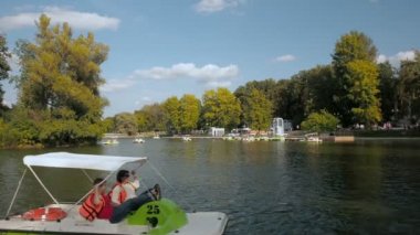 Moskova, Rusya 29 Ağustos 2017 : Aileleri olan insanlar Gorky Park, Mosccow'daki bir gölette yürüyen bir katamarana biniyor