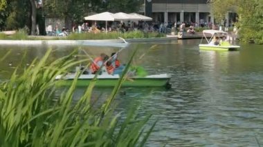 Moskova, Rusya 29 Ağustos 2017 : Aileleri olan insanlar Gorky Park, Mosccow'daki bir gölette yürüyen bir katamarana biniyor