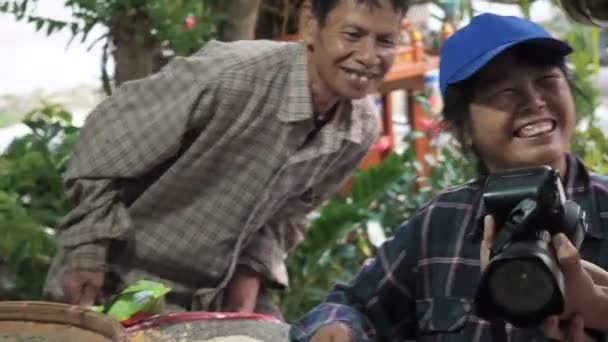 Чиангмай, Таиланд - 23 мая 2019 года: позитивные улыбающиеся люди сортируют кофейные зерна Арабика в маленькой круглой плетеной корзине или бамбуковом сите, контроль качества и выбор кофе — стоковое видео
