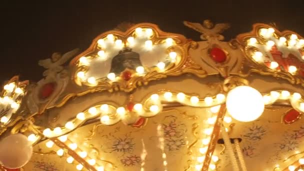 Schön beleuchtete Karussell-Details beim Rundgang auf dem Weihnachtsmarkt in Zeitlupe. Vintage buntes Karussell mit Engel an der Spitze — Stockvideo