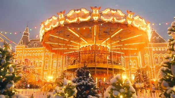 Beautiful brightly glowing carousel on the Red Square decorated and arranged for Christmas and New Year. Christmas fairy illuminated turnabout . Luminous roundabout rotates. Wonderful magic xmas — Stock Video