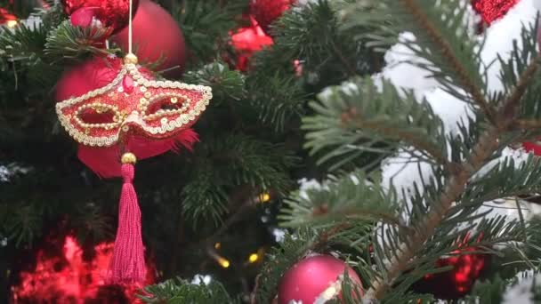 Máscara de carnaval roja veneciana colgando del árbol de Navidad. Fondo de Navidad y Año Nuevo. Decoraciones de Navidad calle — Vídeo de stock