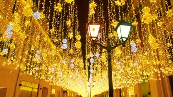 밝은 크리스마스 거리 조명입니다. 도시는 크리스마스 를 위해 장식되어 있습니다. 새해 조명 장식 반짝 보케. 모스크바의 니콜스카야 거리에서 불타는 등불. 밝은 축제 — 비디오