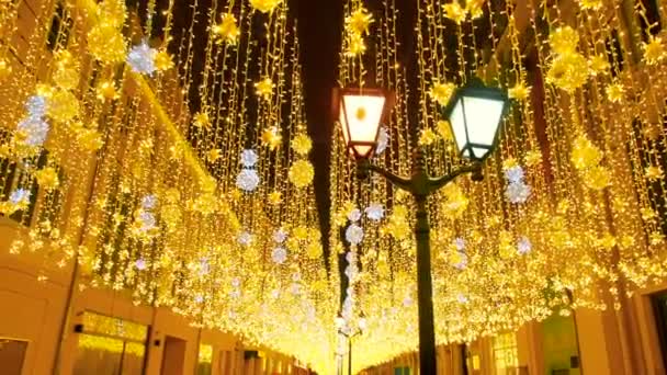 Illuminazione luminosa della strada di Natale. La città è decorata per la festa di Natale. Luci di Capodanno Decorare Bokeh scintillante. Lanterne in fiamme in via Nikolskaya a Mosca. Luminoso festivo — Video Stock